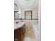 Bathroom features tiled walls, a tub, and a wooden framed mirror above the sink at 7104 Combs Rd, Indianapolis, IN 46237