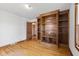 Bedroom with hardwood floors, built-in shelving, and a view into an adjacent room at 7104 Combs Rd, Indianapolis, IN 46237