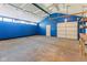 Garage features a white door, blue walls, and high ceilings with track lighting at 7104 Combs Rd, Indianapolis, IN 46237
