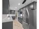 Bright kitchen with stainless steel appliances, sleek grey cabinets, marble countertops and tile flooring at 7104 Combs Rd, Indianapolis, IN 46237