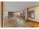 Spacious living room with a brick fireplace, original wood flooring, and large windows for natural light at 7104 Combs Rd, Indianapolis, IN 46237