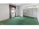 Room with painted green floors, a window with curtains, and shelving units at 7104 Combs Rd, Indianapolis, IN 46237