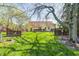 Large backyard with a deck, privacy fence, and mature trees, perfect for outdoor enjoyment at 7114 Hickory Rd, Indianapolis, IN 46259