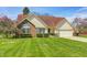 Charming single-Gathering home with a brick and siding facade, manicured lawn, and blossoming trees at 7114 Hickory Rd, Indianapolis, IN 46259