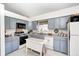 Traditional kitchen featuring gray cabinets, stainless appliances, and an island with additional counter space at 7114 Hickory Rd, Indianapolis, IN 46259