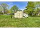Outdoor storage shed with double doors surrounded by a well-maintained lawn and mature trees at 7114 Hickory Rd, Indianapolis, IN 46259