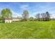 Expansive backyard featuring a large grassy area, mature trees, and a storage shed at 7114 Hickory Rd, Indianapolis, IN 46259