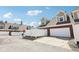 Townhome garages with brick accents, white doors, and privacy fences under a bright sky at 720 Bucksport Ln, Westfield, IN 46074