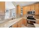 Kitchen featuring stainless steel appliances, light wood cabinetry, stone backsplash and bright lighting at 720 Bucksport Ln, Westfield, IN 46074