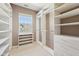A walk-in closet featuring custom shelves, drawers, and a window for natural light at 720 Bucksport Ln, Westfield, IN 46074