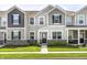 Charming townhome featuring stone accents, gray siding, black shutters, and a well-manicured front lawn at 7265 Governors Row, Avon, IN 46123