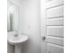 This powder room features a pedestal sink, a mirror, and a crisp, white door at 7265 Governors Row, Avon, IN 46123
