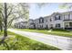 Scenic street view of a neighborhood featuring stylish townhomes and lush greenery along the sidewalks at 7265 Governors Row, Avon, IN 46123