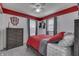 Stylish bedroom featuring red accent paint above the wall, gray curtains and a matching bedspread creating a cozy space at 7860 Sergi Canyon Dr, Indianapolis, IN 46217