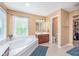 Relaxing bathroom featuring a soaking tub, vanity, and a separate area with toilet and walk-in closet at 8181 Fairway Dr, Brownsburg, IN 46112