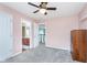Bedroom with neutral carpet, ceiling fan, closet, and views into an adjacent bathroom and hallway at 8181 Fairway Dr, Brownsburg, IN 46112