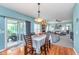 Open concept dining area featuring wood floors, modern lighting, and access to outdoor patio at 8181 Fairway Dr, Brownsburg, IN 46112