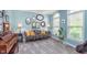 Cozy living room featuring a floral sofa, decorative mirrors, and ample natural light from the window at 8181 Fairway Dr, Brownsburg, IN 46112