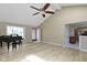 Sunlit living room boasts a vaulted ceiling, fan, hardwood flooring, and grand piano at 8218 San Carlos Ct, Indianapolis, IN 46256
