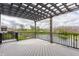 Inviting back porch featuring a wood pergola with views of the water feature and surrounding landscape at 8330 Dumfries Dr, Brownsburg, IN 46112
