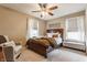 Comfortable bedroom with a wooden bed frame, plush armchair, neutral tones, and bright natural light at 8330 Dumfries Dr, Brownsburg, IN 46112