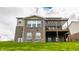 Backyard view of a brick home featuring a covered deck and a lush green lawn at 8330 Dumfries Dr, Brownsburg, IN 46112