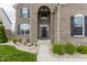 Beautifully landscaped front entrance with brick archway and elegant black front door with glass panels at 8330 Dumfries Dr, Brownsburg, IN 46112