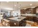 Stylish kitchen with granite countertops, stainless steel appliances, dark wood cabinets, and an island with a sink at 8330 Dumfries Dr, Brownsburg, IN 46112