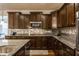 Gourmet kitchen boasting granite countertops, dark cabinetry, stainless steel appliances, and a tiled backsplash at 8330 Dumfries Dr, Brownsburg, IN 46112