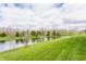 Lush green lawn sloping down to a pond, surrounded by trees and a cloudy sky backdrop at 8330 Dumfries Dr, Brownsburg, IN 46112
