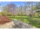 A well-manicured backyard with mature trees and a patio set is perfect for outdoor entertaining at 8639 Lancaster Rd, Indianapolis, IN 46260