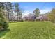 Spacious backyard with mature trees and a well-maintained lawn surrounding the blue and brick home at 8639 Lancaster Rd, Indianapolis, IN 46260