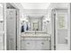 Bathroom with a granite countertop, white cabinets, and a large mirror at 8639 Lancaster Rd, Indianapolis, IN 46260