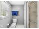 Bathroom with a toilet, towel rack, and shower with glass door next to a window with blinds at 8639 Lancaster Rd, Indianapolis, IN 46260