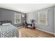Clean bedroom with hardwood floors, desk, study area, and plenty of natural light from the windows at 8639 Lancaster Rd, Indianapolis, IN 46260