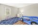 Bright bedroom featuring wood floors, a playful car-shaped bed, and plenty of natural light from the window at 8639 Lancaster Rd, Indianapolis, IN 46260