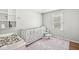 Bright Bedroom with a white crib, patterned rug, comfortable chair, and natural light from the window at 8639 Lancaster Rd, Indianapolis, IN 46260