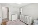 Bright Bedroom with a white crib, dresser, shelves, patterned rug and carpet, creating a cozy space at 8639 Lancaster Rd, Indianapolis, IN 46260