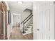 Inviting entrance hallway with hardwood floors, staircase, and views into the dining room at 8639 Lancaster Rd, Indianapolis, IN 46260