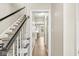 Bright hallway featuring hardwood floors and a staircase with black and white accents at 8639 Lancaster Rd, Indianapolis, IN 46260