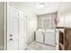 Well-lit laundry room with washer, dryer, exterior door, and storage at 8639 Lancaster Rd, Indianapolis, IN 46260