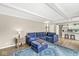 Living room with blue sofa and ottoman, hardwood floors, and view to kitchen area at 8639 Lancaster Rd, Indianapolis, IN 46260