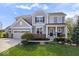 Charming two-story home with a manicured lawn, a three-car garage, and a welcoming front porch with white columns at 957 Commander Ct, Westfield, IN 46074