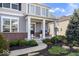 The home features a cozy front porch with rocking chair, beautiful landscaping, and a welcoming entrance at 957 Commander Ct, Westfield, IN 46074