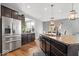 Modern kitchen boasts stainless steel appliances, granite counters, and dark wood cabinets at 957 Commander Ct, Westfield, IN 46074