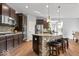 The open-concept kitchen features dark cabinetry, stainless steel appliances, a center island, and pendant lighting at 957 Commander Ct, Westfield, IN 46074