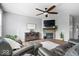 Cozy living room features a fireplace, ceiling fan, hardwood floors, and large windows that provide natural light at 957 Commander Ct, Westfield, IN 46074