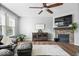 Cozy living room features a fireplace, ceiling fan, hardwood floors, and large windows that provide natural light at 957 Commander Ct, Westfield, IN 46074