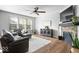 Cozy living room features a fireplace, ceiling fan, hardwood floors, and large windows that provide natural light at 957 Commander Ct, Westfield, IN 46074