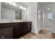 Bathroom vanity with dual sinks, dark wood cabinets, and a view into a connected room at 10138 Redwood Peak Ln, Indianapolis, IN 46259